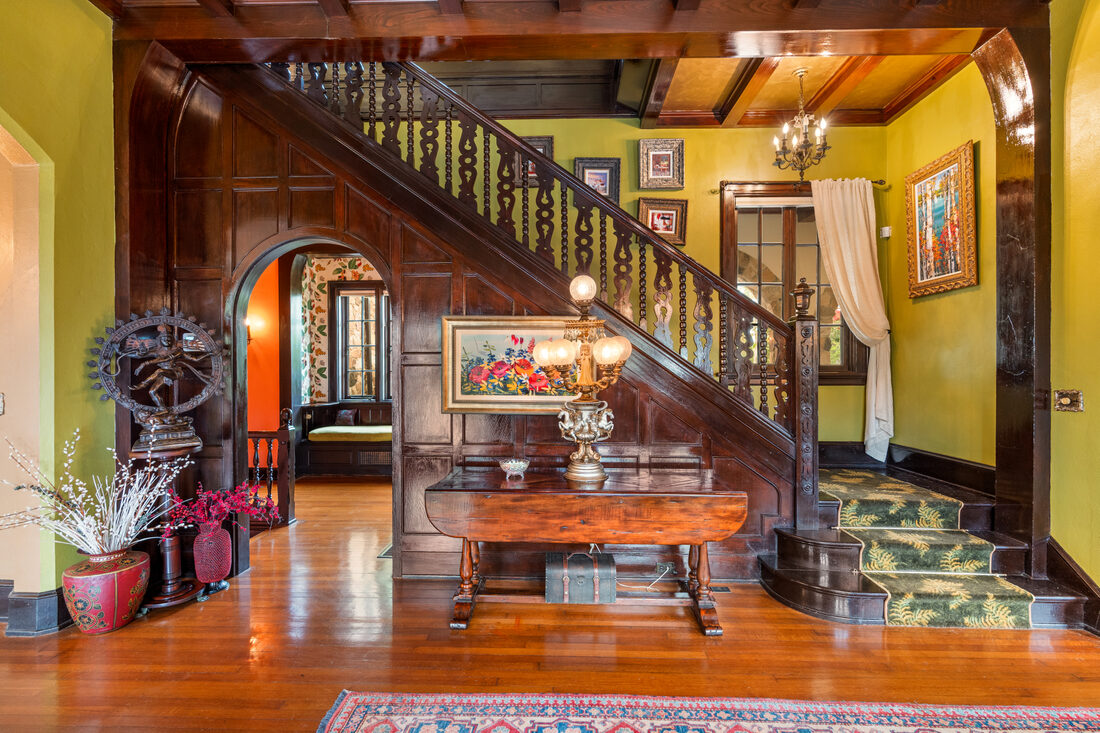 Beamed and paneled foyer with hand-carved staircase